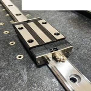 Linear guide rail carriage mounted on a profile rail showing flanged block design used in CNC motion systems